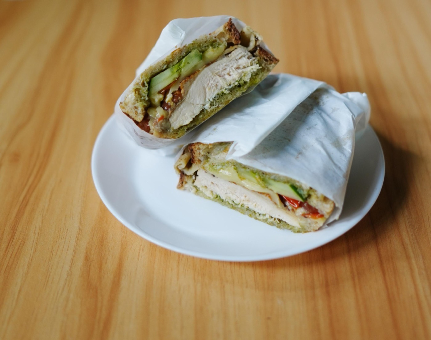 Basil chicken pesto sandwich on sourdough, wrapped and halved, at LITO Bakery Cafe in Bangsar